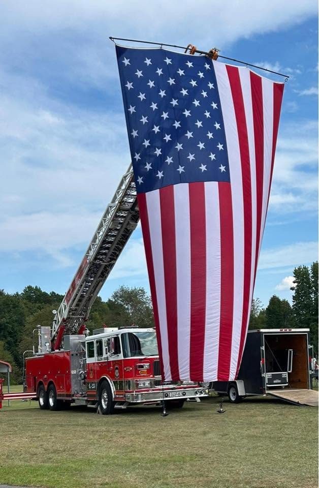 A large American flag hanging from Crains Creek's aerial ladder. Photo posted by Crains Creek Fire-Rescue.